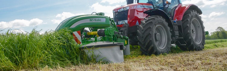 Ein McHale Pro Glide F3100 im Einsatz auf dem Fleid im Gras. An einem Massey Ferguson
