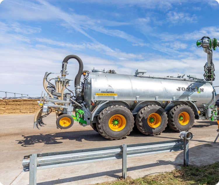 Volumetra Güllefass steht auf einem Hof vor einem Silo
