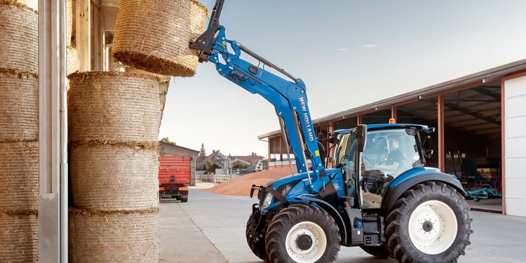 New Holland der einen Heuballen hebt Header Foto